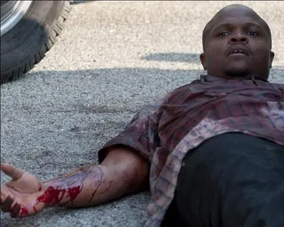 T-Dog a une crise de délire suite à une crise de septicémie. Comment s'est-il blessé au bras  ?